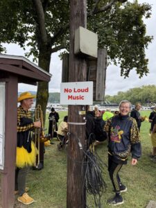 band members standing next to a "No loud music" sign